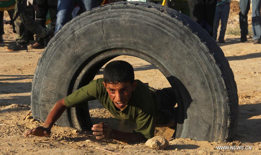 Un gar?on palestinien participe à un exercice militaire lors d'une cérémonie de fin d'études d'une école militaire organisée par le hamas dans la ville de Rafah, dans le sud de Gaza, le 19 juin 2013. (Xinhua/Khaled Omar)