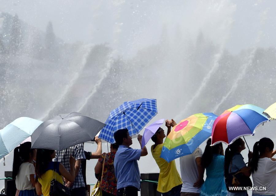 Des gens se rafra?chissent près d'une fontaine musicale à Hangzhou, capitale de la province du Zhejiang (est de la Chine), le 28 juillet 2013. Une vague de chaleur a frappé de nombreuses régions de la Chine ces derniers jours.