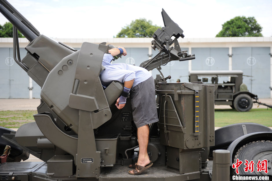 Un correspondant étranger explore le magasin de munitions d'une pièce d'artillerie.