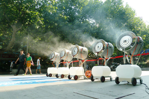 Face à la canicule, cinq ventilateurs de refroidissement ont été placés devant un magasin de Nanjing pour rafra?chir les passants, dans la province chinoise du Jiangsu à l'est du pays, le 29 juillet 2013.