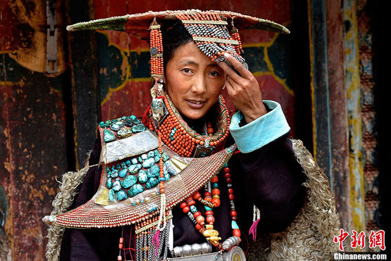 Le 8 juillet 2013, dans le village de Kagayi du district de Burang situé dans la préfecture Nagari de la région autonome du Tibet en Chine, une femme porte le costume traditionnel tibétain – le costume du paon. (Photo : Chinanews /Li Lin)