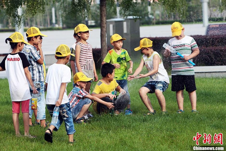 Le 4 ao?t vers le soir, à Taiyuan, dans le Shanxi, des enfants s'amusent avec de l'eau.