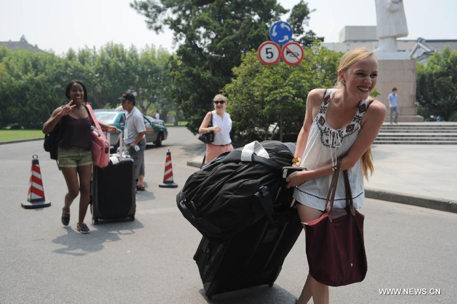 Le 11 ao?t 2013, plusieurs étudiants étrangers de l'Université New York-Shanghai marchent avec leurs valises sur le campus de l'Université normale de l'Est de Chine. (Photo : Xinhua/Liu Xiaojing)