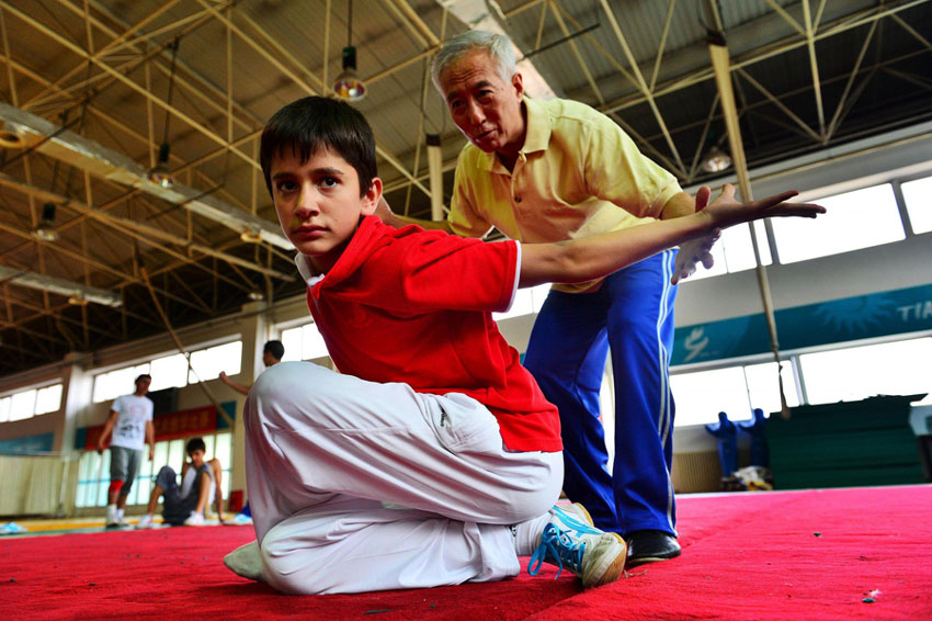 Yuan Xi, ma?tre chinois de kung-fu, guide Christopher, un étudiant de 13 ans originaire d'Allemagne, dans la pratique de mouvements d'arts martiaux à Tianjin, en Chine du Nord, le 21 ao?t 2013. [Photo / Xinhua]