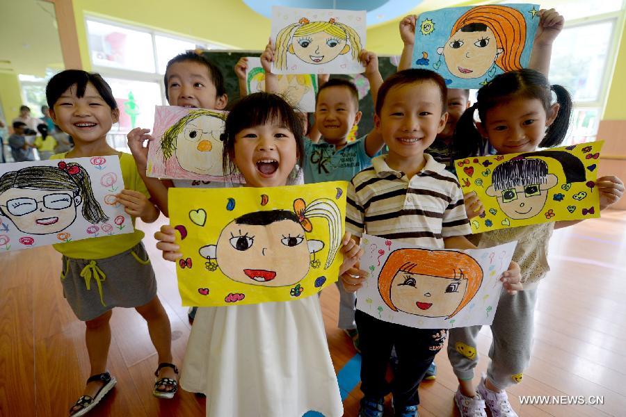 Lundi 9 septembre 2013 dans une école maternelle de Hefei dans la province de l'Anhui, à la veille de la Fête des Enseignants, des enfants dessinent les visages souriants de leurs ma?tresses avant de leur en faire cadeau. (Photo : Xinhua/Zhuang Duan)