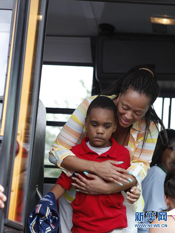 Le 20 ao?t 2013 à Decatur en Georgie aux Etats-Unis, après une fusillade survenue dans une école primaire, la police et les enseignants ont évacué près de 800 élèves. Sur cette image, une ma?tresse accompagne un jeune gar?on choqué par l'incident. (Photo : Xinhua/Reuters)