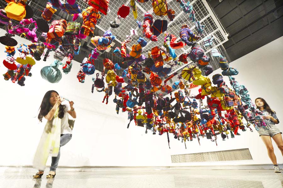 Une visiteuse immortalise l'?uvre de l'artiste britannique Alinah Azadeh, lors de la 1ère édition de la Triennale des Arts textiles à Hangzhou, la capitale de la province du Zhejiang dans l'est de la Chine, le 21 septembre 2013.