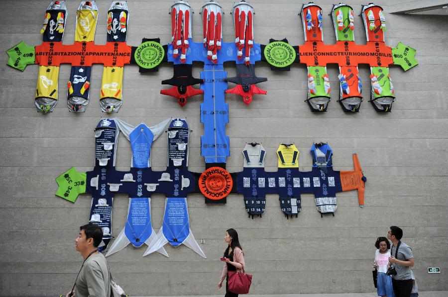 Les visiteurs admirent le travail du couple fran?ais Lucy et Jorge Orta, lors de la 1ère édition de la Triennale des Arts textiles à Hangzhou, la capitale de la province chinoise du Zhejiang dans l'est du pays, le 21 septembre 2013. L'événement à ouvert ses portes samedi au Musée des Beaux-Arts de Zhejiang et au Musée national de la soie, une triennale internationale qui va durer deux mois, où 186 pièces et ?uvres de 45 artistes seront exposées. [Photo/Xinhua]