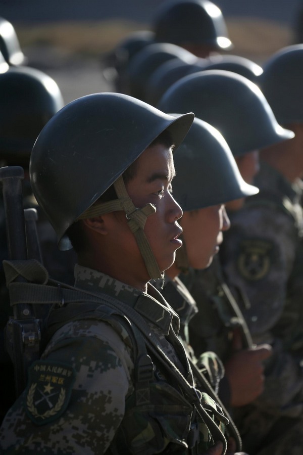 Des soldats se préparent à prendre part à un entra?nement militaire sur la région du plateau dans la Région autonome ou?goure du Xinjiang, le 8 septembre 2013. [Photo / Xinhua]