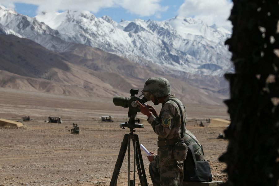 Un soldat chinois observe une cible lors d'un entra?nement militaire sur la région du plateau dans la Région autonome ou?goure du Xinjiang, le 6 septembre 2013. [Photo / Xinhua]