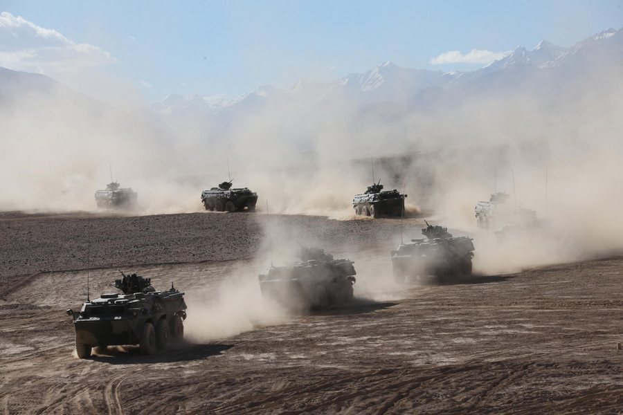 Des véhicules blindés à pleine vitesse sur la région du plateau dans la Région autonome ou?goure du Xinjiang, dans le cadre d'exercices militaires, le 6 septembre 2013. [Photo / Xinhua]