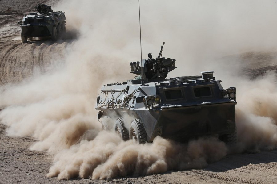 Des véhicules blindés à pleine vitesse sur la région du plateau dans la Région autonome ou?goure du Xinjiang, dans le cadre d'exercices militaires, le 6 septembre 2013. [Photo / Xinhua]