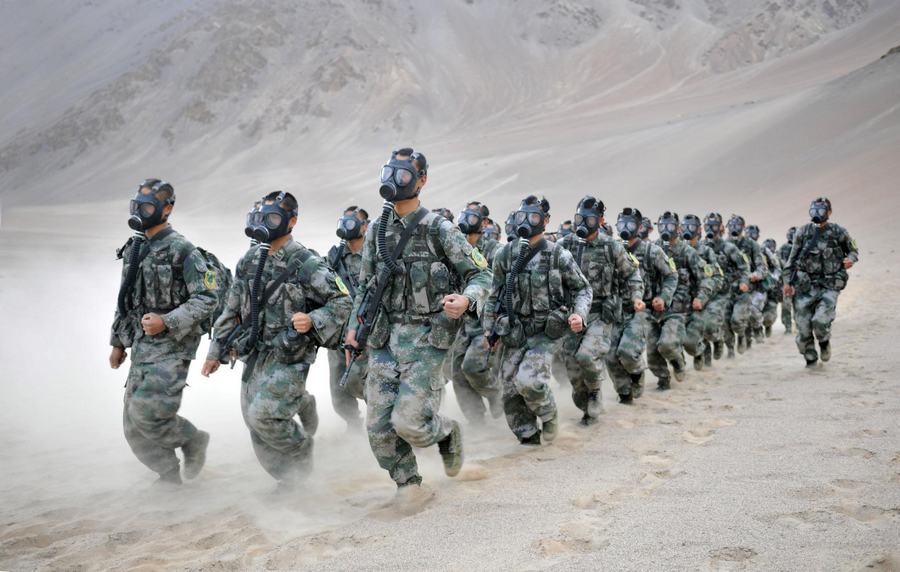 Des soldats chinois portant des masques à gaz prennent part à un entra?nement militaire sur la région du plateau dans la Région autonome ou?goure du Xinjiang, le 5 septembre 2013. [Photo / Xinhua]