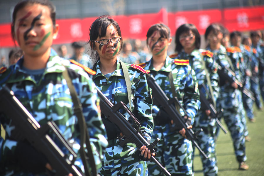 Des étudiantes universitaires armées de fusils d'assaut font montre de leurs compétences lors d'un show militaire à l'Université du Shandong, à Jinan, dans la Province du Shandong en Chine de l'Est, le 26 septembre 2013. [Photo Zheng Tao / Asianewsphoto]