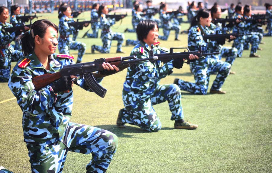 Une escouade d'étudiantes universitaires armées de fusils d'assaut a fait ses débuts devant des spectateurs ébahis à l'Université du Shandong, à Jinan, dans la Province du Shandong en Chine de l'Est, le 26 septembre 2013. Les étudiantes de première année universitaire ont offert un spectacle militaire à la fin de la formation militaire des nouveaux étudiants sur le campus. [Photo Zheng Tao / Asianewsphoto]