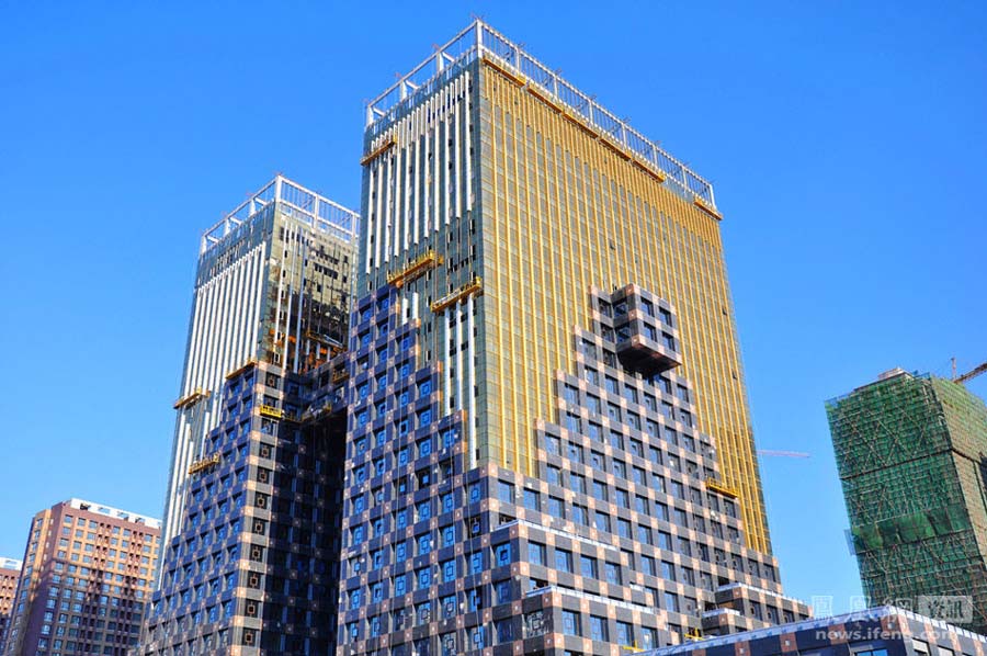 A Shenyang, capitale de la Province du Liaoning, au c?ur du District de Tiexi, une construction bicolore, dont la partie supérieure est jaune, et la partie inférieure brune. Composé de deux batiments formant la lettre H de l'alphabet latin, sa conception architecturale est inspirée des tripodes ? ding ? de l'antiquité et des monnaies anciennes. Jaune en haut et brun en bas, il comporte au milieu de la ? jambe ? une partie cubique proéminente qui, touchée par les rayons du soleil de midi irradie d'immenses reflets d'or sur le batiment jaune. Photo / Yan Bo 