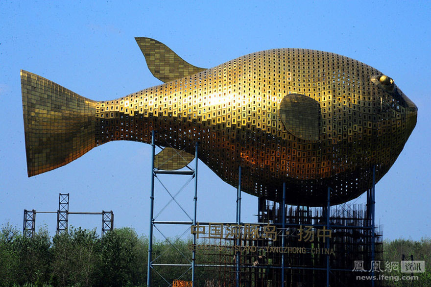 Au Jardin d'Exposition Horticole de Yangzhong, dans la Province du Jiangsu. D'une largeur de 44 mètres, haut de 62 mètres, et long de 90 mètres, le ? Poisson globe ? géant, est devenu le batiment symbole de la ville de Yangzhong, et a été baptisé la ? Tour poisson globe de Chine ?. Con?u par l'Institut de design architectural de l'Université de Tongji, il pèse environ 2 100 tonnes et est recouvert d'une mosa?que de plus de 7 000 plaques différentes de laiton diversement orientées, reproduisant l'épiderme de l'animal. Le poisson-globe géant est actuellement inscrit au Livre Guinness des Records en tant que plus grand de son genre au monde.