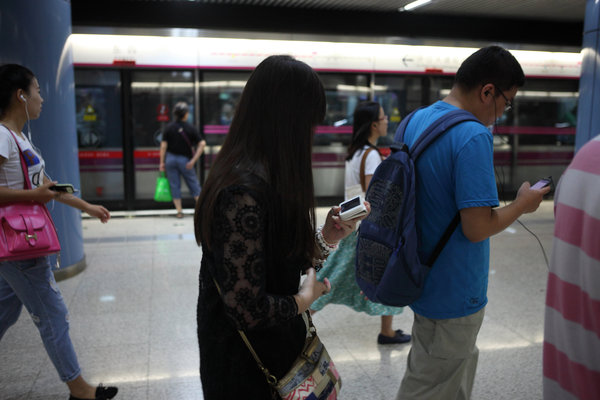 Ils sont nombreux à scruter l'écran de leurs mobiles, tout en marchant dans le métro à Beijing le 31 ao?t 2013.