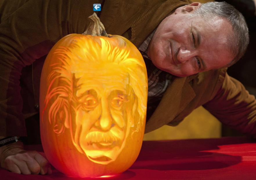 L'artiste Hugh McMahon aux c?tés de la citrouille d'Albert Einstein, qu'il a sculptée pour le musée Madame Tussauds à New York, le 22 octobre 2013. 