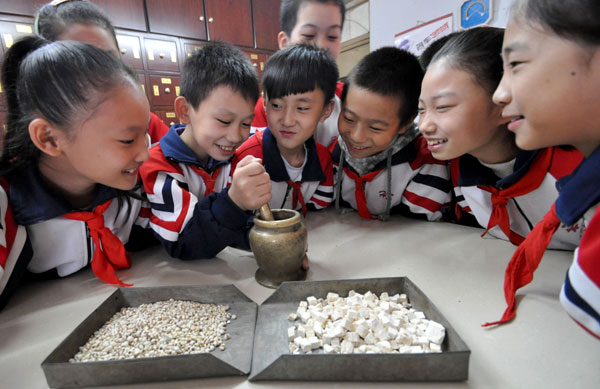 Des élèves de l'école primaire Zhuhelu de Handan essayent de broyer des médicaments à la pharmacie du deuxième H?pital de Handan, dans la ville de Handan, province du Hebei, le 21 octobre 2013. [Photo Hao Qunying / Asianewsphoto]