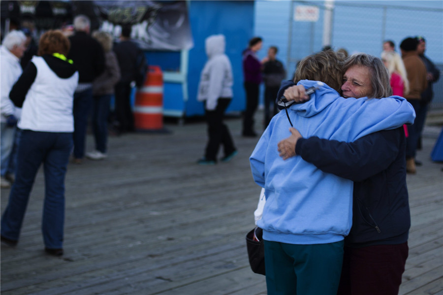 Deux femmes se rencontrent pour la première fois en un an alors qu'elles participent à une manifestation d'illumination de la c?te pour le premier anniversaire de l'ouragan Sandy à Seaside Heights, dans le New Jersey, le 29 octobre 2013.