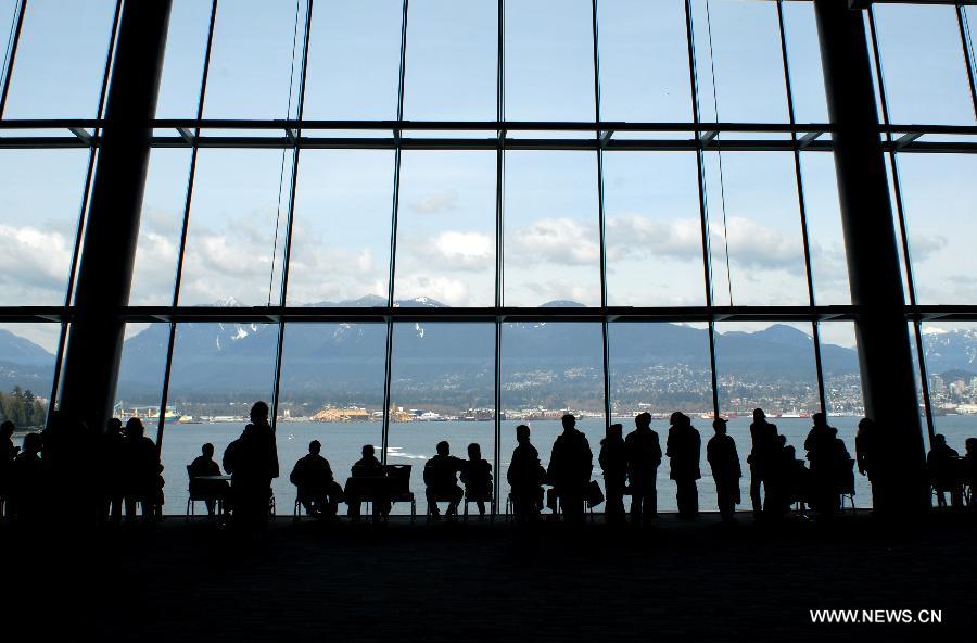 Les gens regardent la Rive nord depuis le Centre de Convention de Vancouver, au Canada, le 4 novembre 2013. (Xinhua/Sergei Bachlakov)