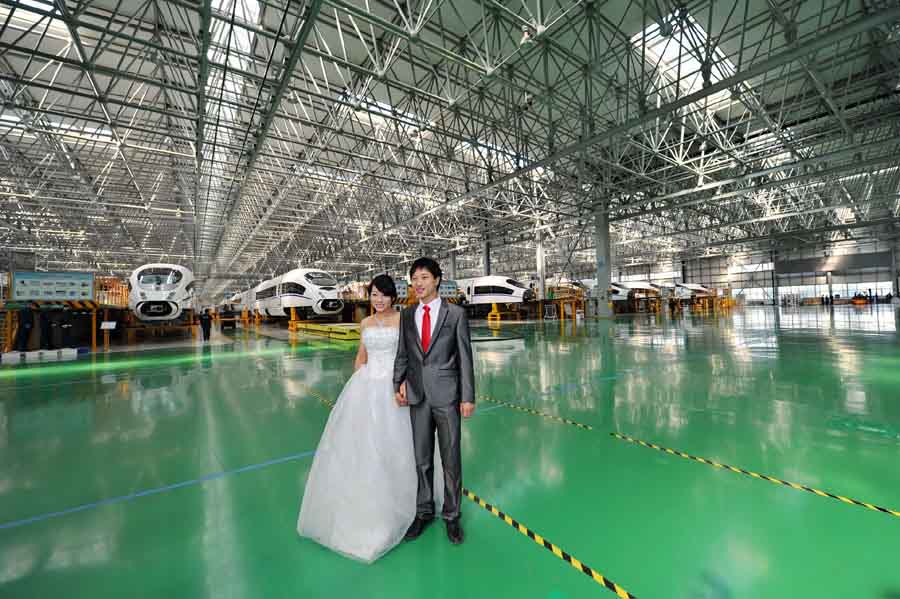 Deux ouvriers, qui ont organisé leur mariage dans une usine de fabrication du train à grande vitesse à Beijing, en 2013. [Photo / Xinhua]