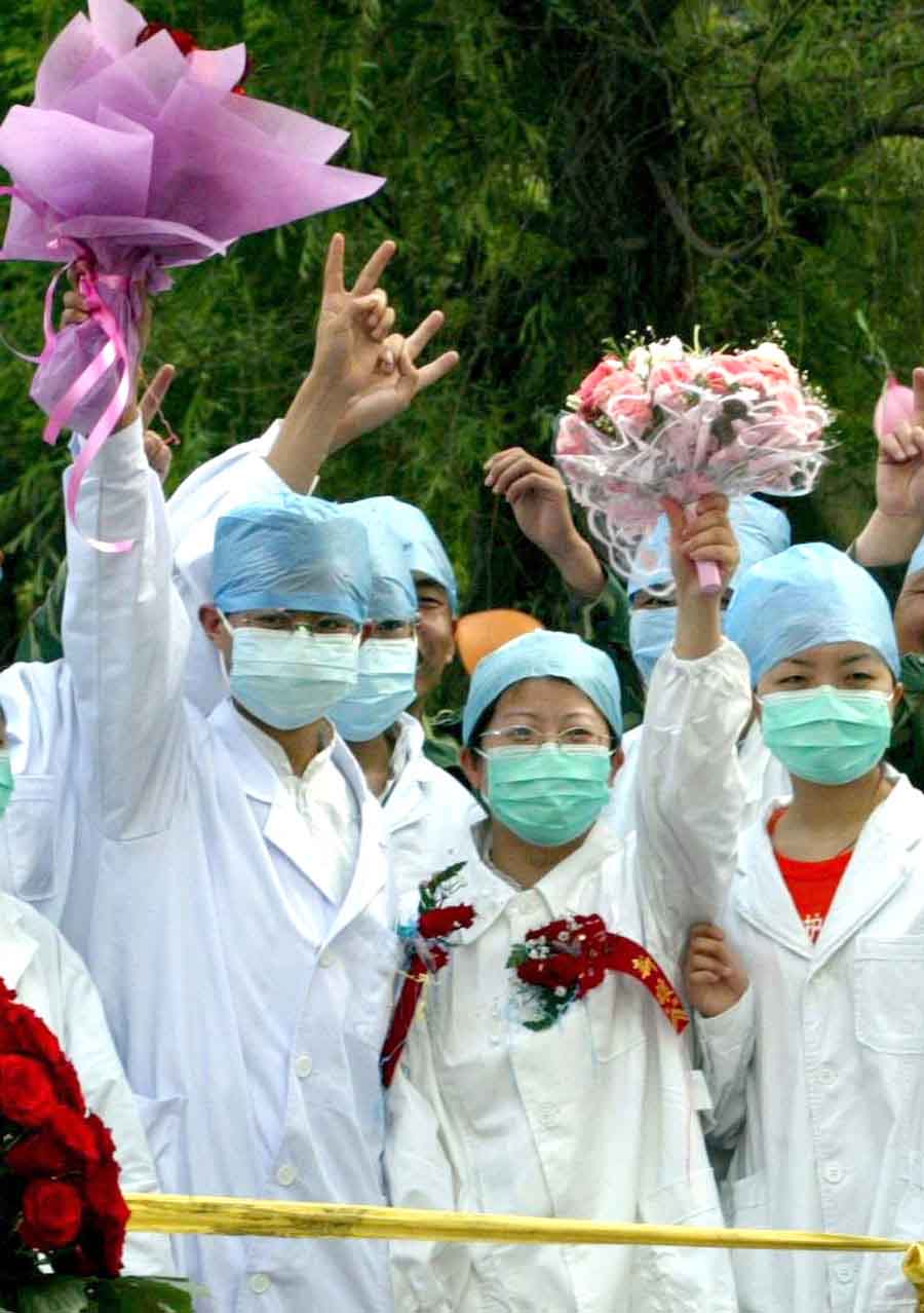 Des médecins lors de leur cérémonie de mariage dans une zone d'isolement d'un h?pital de Tianjin pendant l'épidémie de SRAS en 2003. [Photo / Xinhua]