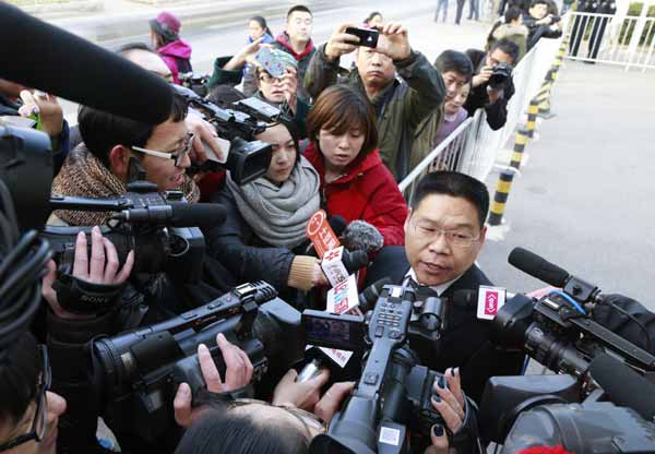 Zhang Qihuai, l'avocat du jeune Li, qui a déposé un recours devant la Cour populaire intermédiaire No 1 de Beijing, salue le public en arrivant au tribunal le 19 novembre 2013. [Photo Feng Yongbin / Asianewsphoto]