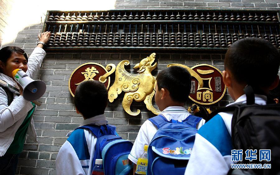 Le 6 avril 2007, des élèves regardent un boulier chinois géant dans un village culturel à Zhongshan dans la province du Guangdong en Chine. (Photo : Xinhua/Zhou Wenhua)