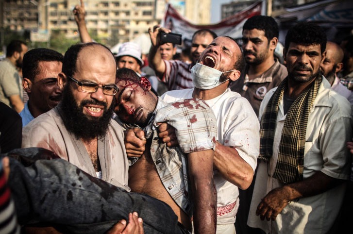 Le 27 juillet 2013, les forces de l'ordre égyptiennes commencent à attaquer les manifestants qui occupent depuis deux mois la place Rabaa Adaweya au Caire. Deux hommes, ne semblant pas réaliser que l'homme dans leurs bras est déjà mort, ne cessent d'appeler à l'aide. Photo prise par Mosa'ab Elshamy.