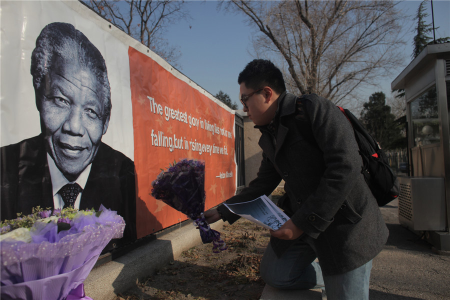 Un homme vient rendre hommage à l'ancien président sud-africain Nelson Mandela, en face de l'ambassade d'Afrique du Sud à Beijing, le 6 décembre 2013. Nelson Mandela, héros anti- apartheid sud-africain est décédé paisiblement chez lui à l'age de 95 ans jeudi, après des mois de lutte contre une infection pulmonaire. [photo Wang Jing / Asianewsphoto]