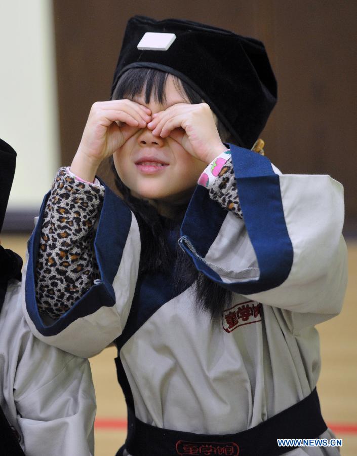 Un élève portant un costume traditionnel de la dynastie des Han (202 BC- 220 AD) s'amuse dans une école privée à Changsha, la capitale de la province du Hunan (centre de la Chine), le 7 décembre 2013. [Photo/Xinhua]