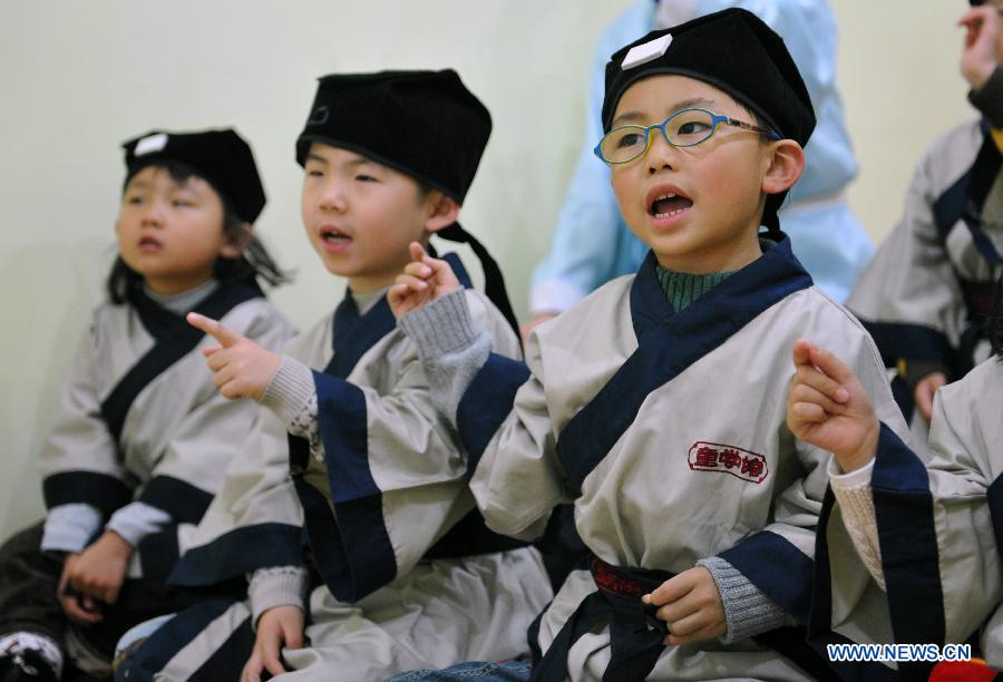 Des étudiants portent de costumes traditionnels de la dynastie des Han (202 BC- 220 AD) lors d'un cours dans une école privée à Changsha, la capitale de la province du Hunan (centre de la Chine), le 7 décembre 2013. Un groupe d'élèves de moins de 12 ans suivent le week-end des cours de culture traditionnelle chinoise dans une école privée, récemment ouverte à Changsha. [Photo/Xinhua]