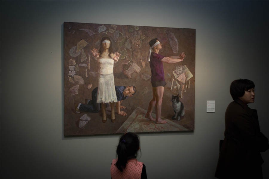 Une jeune fille admire une peinture à l'exposition d'art présentant des ?uvres des professeurs de l'ACBC à l'Académie Centrale des Beaux-Arts de Chine. [Photo fournie au  China Daily]