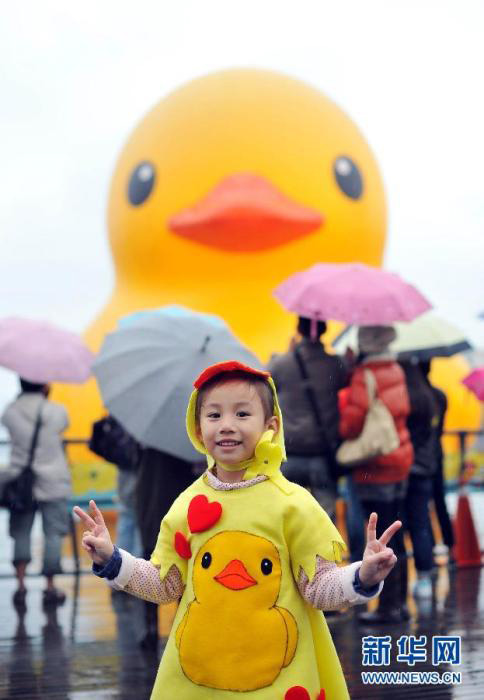 Le 21 décembre, une enfant portant une veste avec un motif de petit canard jaune a pris une photo avec le canard géant jaune, qui a fait une apparition officielle le même jour dans le port de Jilong. Des dizaines de milliers de visiteurs se sont réunis sur la Place de la Mer de Jilong sous la pluie pour admirer cette ?uvre de l'artiste Florentijn Hofman. Il a été annoncé que le canard d'une hauteur de 18 mètres passerait No?l et le Nouvel An avec les visiteurs. Source : Xinhua [Photo / Chen Yehua]