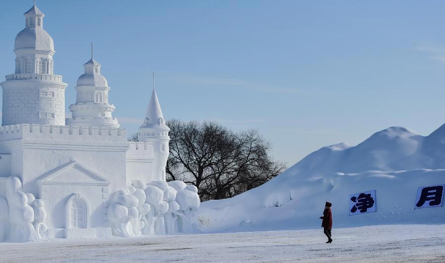 Un visiteur regarde une sculpture de neige dans le parc national forestier Jingyuetan à Changchun, capitale de la province du Jilin, en Chine du Nord, le 2 janvier 2014. Le ? Jingyue Snow World ?, qui compte de nombreuses de sculptures de neige, a été ouvert aux touristes jeudi. [Photo / Xinhua]