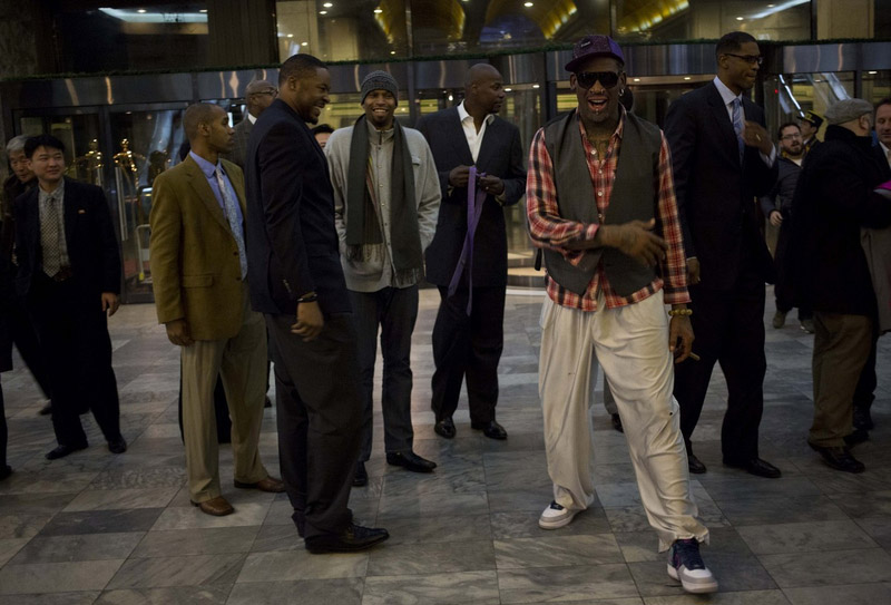 L'ancienne star de la NBA de basket Dennis Rodman, au premier plan à droite, et des joueurs de basket-ball américains arrivent dans un h?tel à Pyongyang, en Corée du Nord, lundi 6 janvier 2014.