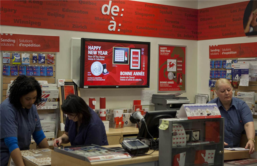 Une étudiante chinoise montre ses enveloppes premier jour de l'Année du Cheval dans un bureau de poste à Toronto, le 13 janvier 2014. Les timbres et objets de collection sur l'Année du Cheval sont exposés dans un bureau de poste à Toronto, le 13 janvier 2014. [Photo / Xinhua]