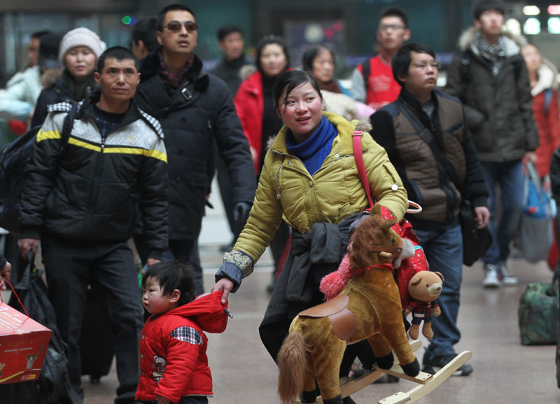 Des passagers attendent pour embarquer à bord d'un train à la gare de l'Ouest de Beijing mardi avant le pic annuel des voyages de la Fête du Printemps de 40 jours, qui commence jeudi. [Photo Zou Hong / China Daily]