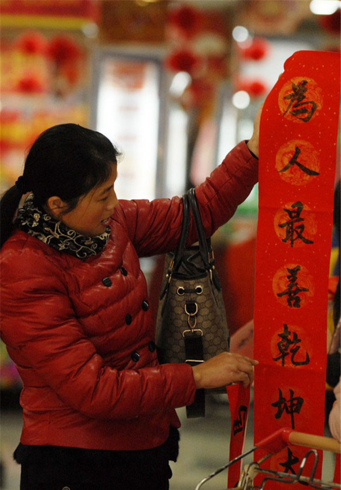 Des sentences parallèles de la Fête du Printemps offertes gratuitement dans un supermarché de la ville de Xuancheng, dans la Province de l'Anhui, en Chine de l'Est, le 17 janvier 2014. [photo / icpress.cn]