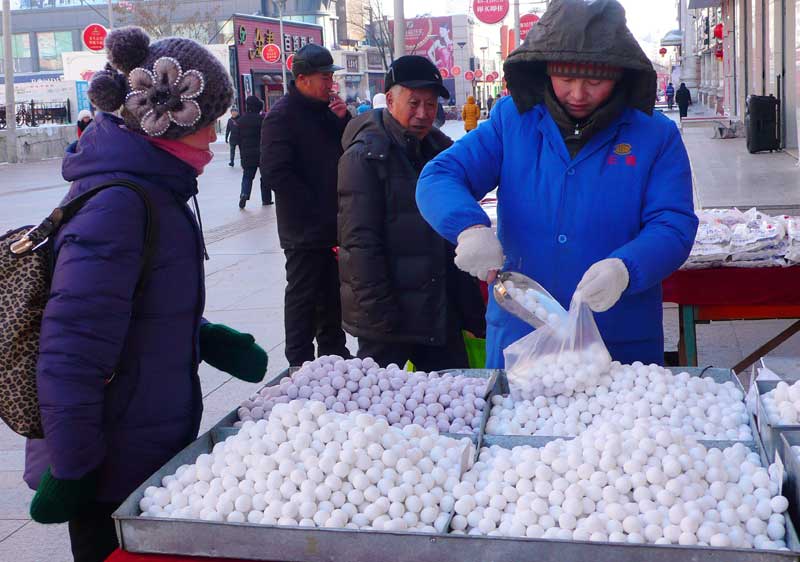 Une femme achète différentes yuanxiao (petites boulettes de pate de riz), le 7 février à Heihe, dans la province chinoise du Heilongjiang. (Photo : Qiu Qilong/Asianewsphoto)