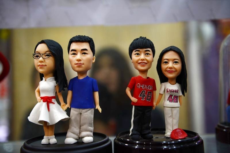 Des ? figurines d'amoureux en pate ? fabriquées par Fu Xinxi, un artiste folklorique de Liaocheng, dans la Province du Shandong, le 9 février 2014. Les figurines en pate de Fu sont populaires chez les couples pour la Saint Valentin. Elles sont fabriquées à partir de farine de blé, de farine de riz gluant et de glycérine cuites à la vapeur, et sont créées à partir de photos fournies par les couples. [Kong Xiaozheng / Asianewsphoto]