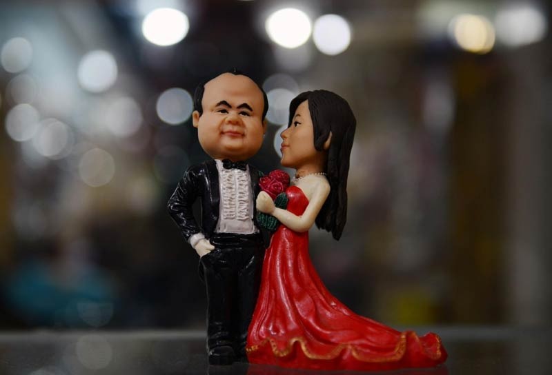 Un couple de ? figurines d'amoureux en pate ? fabriqué par Fu Xinxi, un artiste folklorique de Liaocheng, dans la Province du Shandong, le 9 février 2014. Les figurines en pate de Fu sont populaires chez les couples pour la Saint Valentin. Elles sont fabriquées à partir de farine de blé cuit à la vapeur, de farine de riz gluant et de glycérine cuites à la vapeur, et sont créées à partir de photos fournies par les couples. [photo Xinhua]