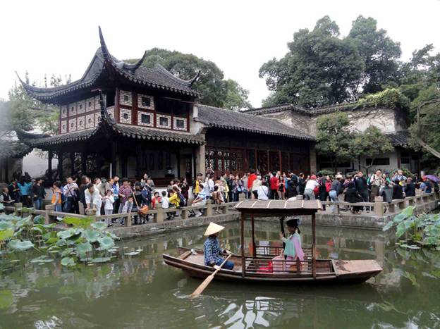 Des touristes se promènent dans un jardin classique de Suzhou. Une artiste joue d'un instrument de musique traditionnel chinois sur un bateau à Suzhou, dans la Province du Jiangsu, le 1er octobre 2011.