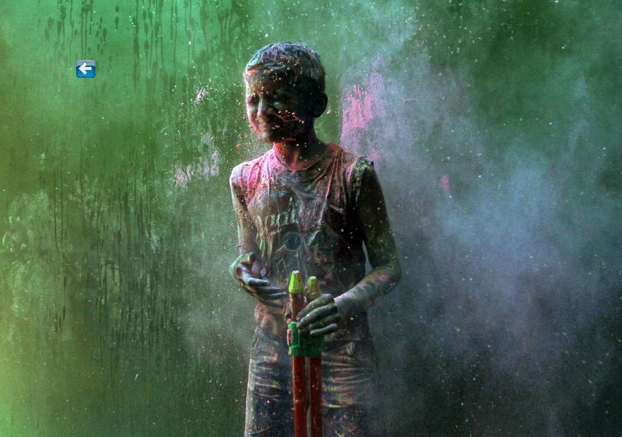 Un jeune gar?on dans une bataille de poudres de couleurs, lors des célébrations du Holi dans la ville indienne méridionale de Chennai, le 16 mars 2014. 