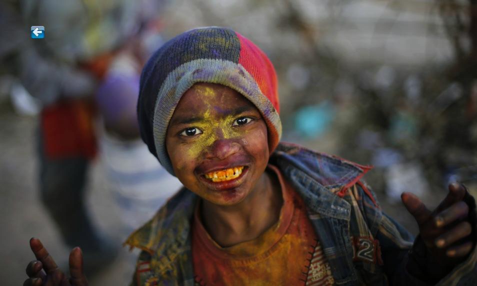 Un jeune gar?on devant l'objectif, en plein célébration du ? Holi ?, le festival indien des couleurs, à New Delhi, le 14 mars 2014.