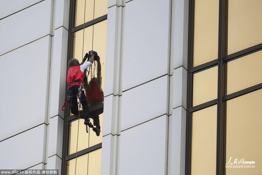 Le 23 avril, le grimpeur fran?ais de haut niveau Alain Robert en pleine escalade de l'h?tel Galaxy à Macao. (Photo : Xinhua/Zhang Jinjia)