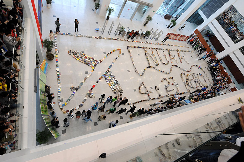 Le 23 avril, à l'occasion de la Journée mondiale du livre, des étudiants de l'Université d'aéronautique et d'astronautique de Nanjing assistent à la tombée de plus de deux mille ouvrages en dominos. (Photo : Xinhua/Sun Can)