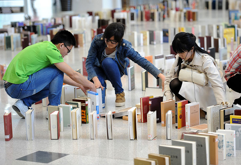 Mercredi 23 avril, des étudiants de l'Université d'aéronautique et d'astronautique de Nanjing s'activent pour mettre en place un jeu de livres en dominos à l'intérieur de la bibliothèque du campus. (Photo : Xinhua/Sun Can)